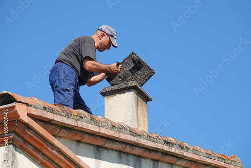 Worker repairs chimney on the roof