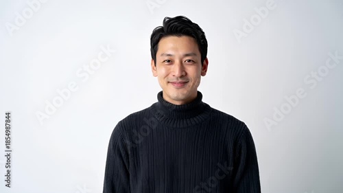 白背景のスタジオで撮影された日本人男性の上半身ポートレート。
ニットセーター姿で、IT・企画・コンサル業界を想起させる清潔感ある印象。
柔らかなライティングと浅い被写界深度により、信頼感と親しみやすさを表現。