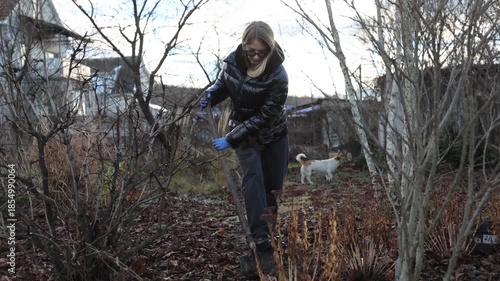Individual clearing earth beside plants under cloudy sky