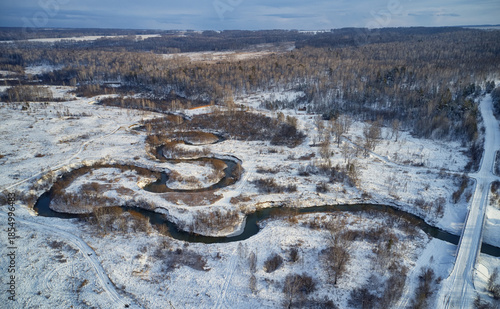 Aerial photo of Koen river and road bridge under ice and snow. Beautiful winter landscape.