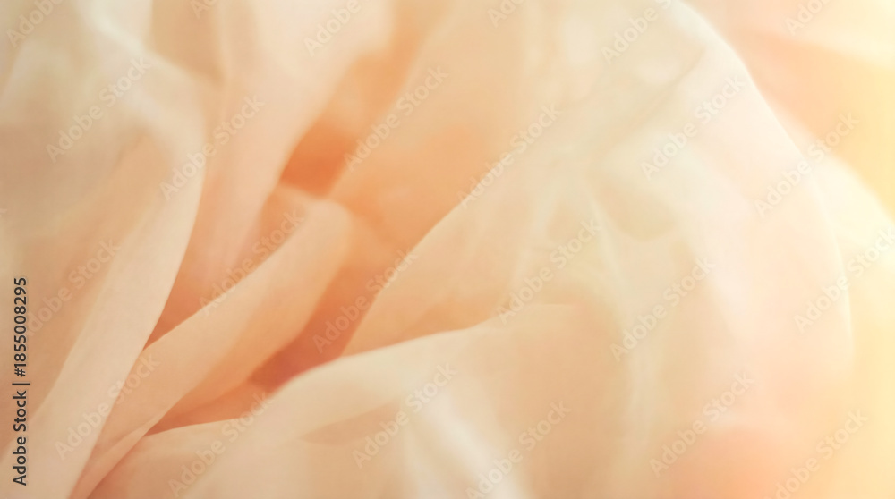 Fototapeta premium Soft peach fabric with gentle folds and a warm, ethereal glow