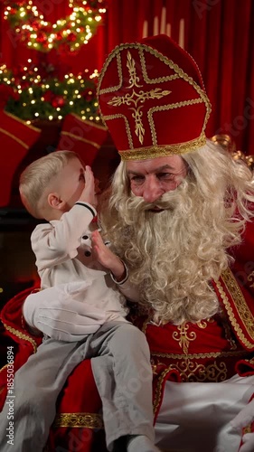 Saint Nicholas with a little boy in a festive Christmas atmosphere. The concept of a festive evening.