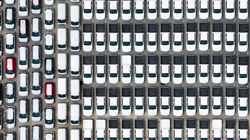 Top view of new cars stock at factory parking lot. Above view cars parked in a row. Automotive industry. Logistics business. Import or export new cars at warehouse. Big parking lot at port terminal
