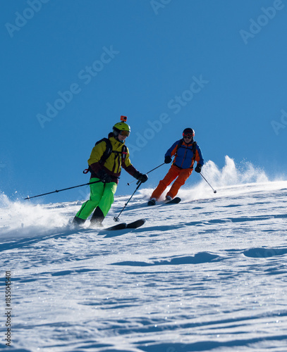Εκτύπωση καμβά Two male skiers descending a snowy slope in unison under a clear blue sky, kicki