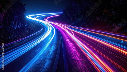 Long exposure shot of car light trails snaking through a mountain pass at night