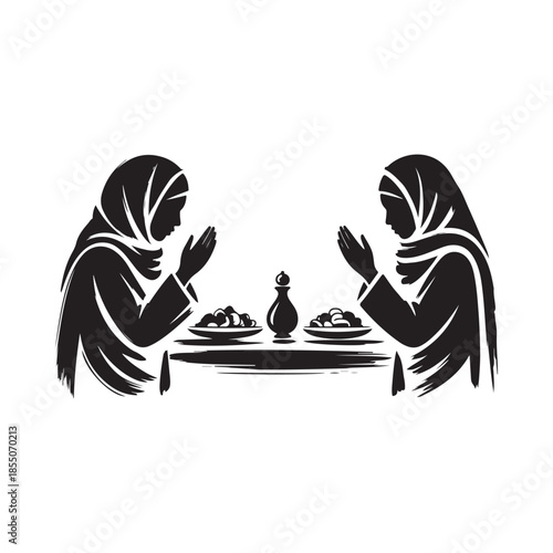 Two women in hijabs praying with food on a table before them