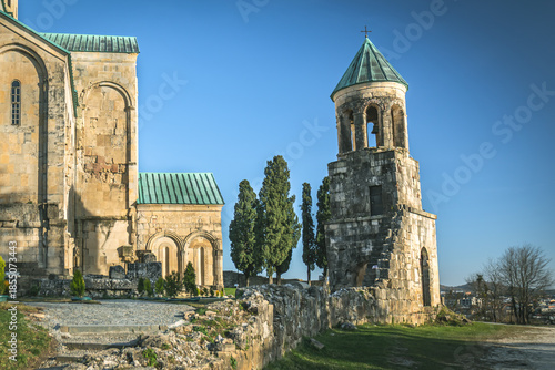 Wallpaper Mural Historic stone church with bell tower and green roof under clear blue sky, photographed on a sunny day in Kutaisi, Georgia. Traditional religious architecture with calm and spiritual atmosphere Torontodigital.ca