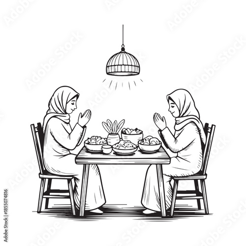 Two women in headscarves praying before a meal at a wooden table