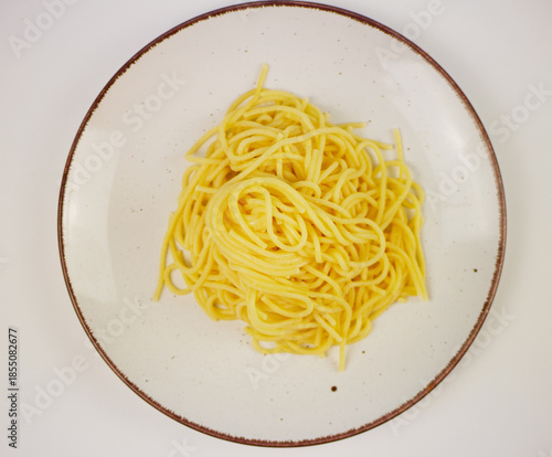 Wallpaper Mural White plate full of cooked spaghetti with a small piece of butter in the middle, top view on neutral background, minimal hot pasta dish for menu design Torontodigital.ca