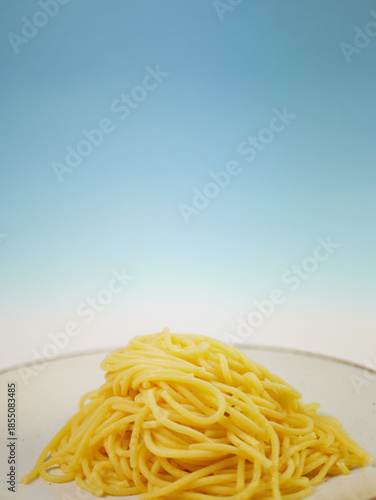 Wallpaper Mural Cooked spaghetti served on a white plate against a clean blue gradient background, simple minimal food composition for ingredient or meal visuals, pro photo Torontodigital.ca
