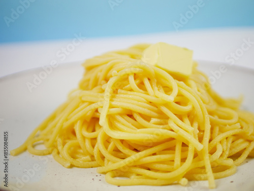 Wallpaper Mural White plate full of cooked spaghetti with a small piece of butter in the middle, top view on neutral background, minimal hot pasta dish for menu design Torontodigital.ca