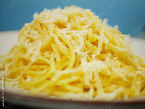 Wallpaper Mural Side closeup of hot spaghetti piled high and topped with grated parmesan cheese on a plate, appetizing cheesy pasta portion for Italian comfort food concepts. Pro Photo Torontodigital.ca
