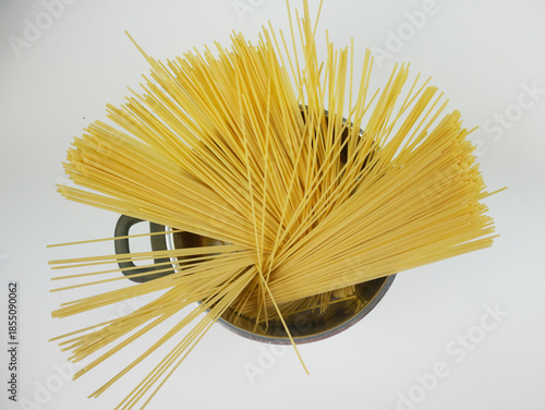 Wallpaper Mural Top view of uncooked spaghetti pasta fanned out in a metal pot on white background, minimal Italian cuisine concept with long dry noodles and kitchen ingredient styling Torontodigital.ca
