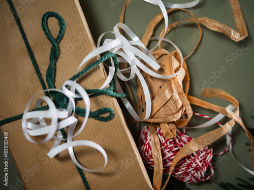 Christmas gift with wrapping ribbon and string green background