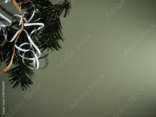 Christmas wrapping ribbon string and pine on green background