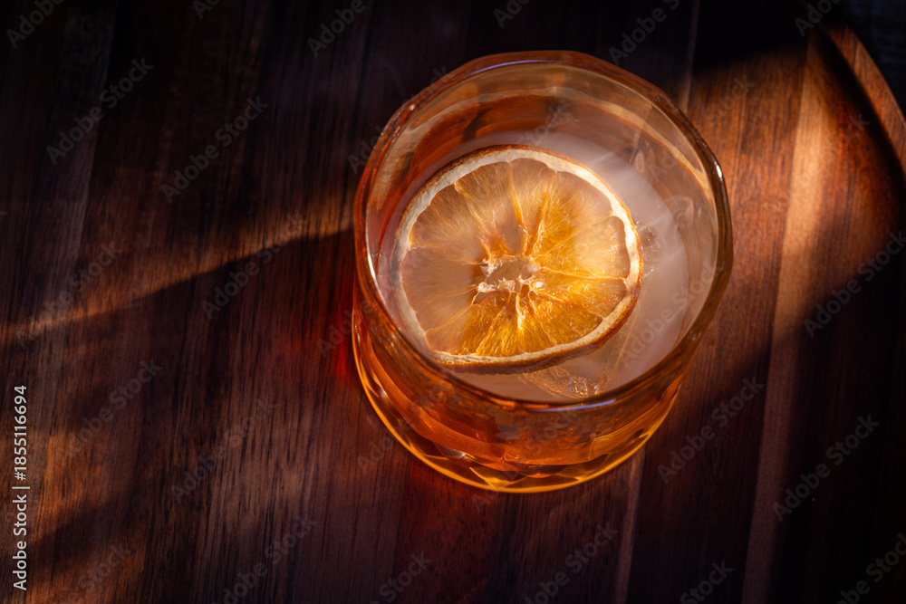 custom made wallpaper toronto digitalwhiskey cocktail served on the rocks garnished with a dehydrated orange slice with dramatic lighting served on a wooden surface.