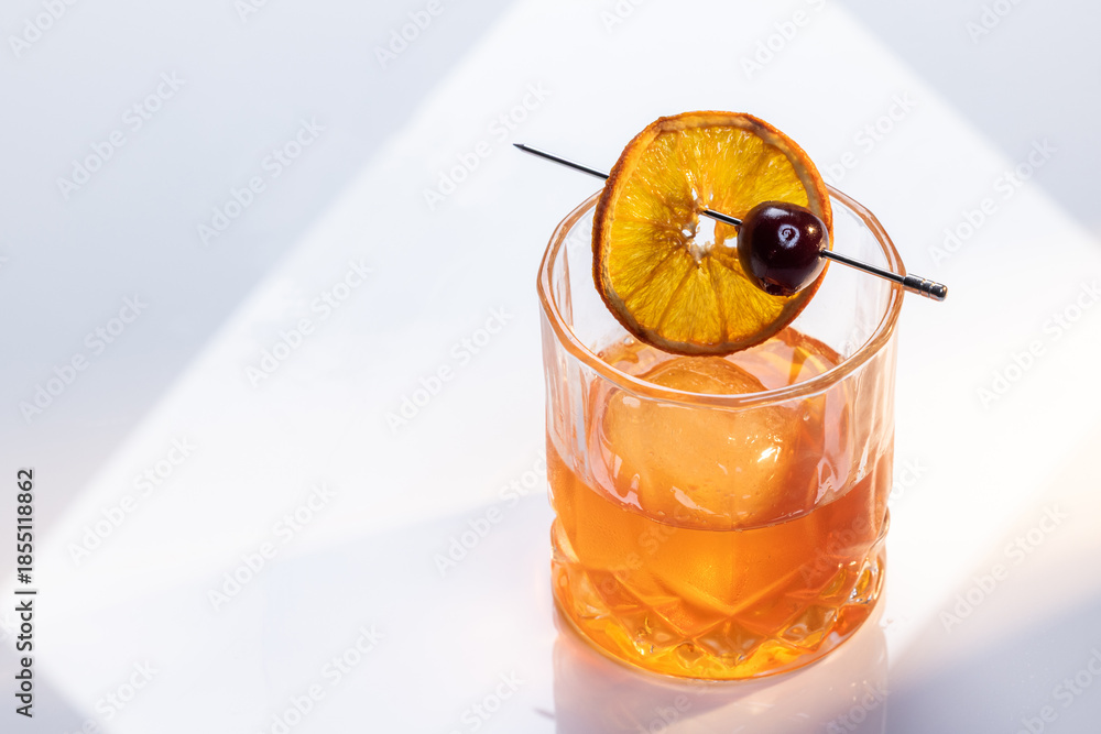 custom made wallpaper toronto digitalClose up of a manhattan cocktail served with one large ice cube on a reflective white surface with dual lighting tones and high contrast lights adding drama.