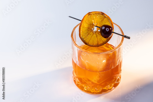 Wallpaper Mural Close up of a manhattan cocktail served with one large ice cube on a reflective white surface with dual lighting tones and high contrast lights adding drama. Torontodigital.ca