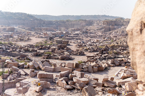stone mining industry scene with exposed rock formations in Aravalli mountain range at day
