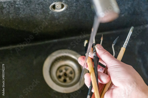 washing paintbrushes in a kitchen sink