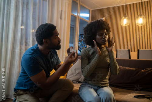 Фотография Couple in living room, man proposing, woman rejecting, tense emotional moment