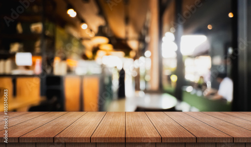 Empty wooden table top with lights bokeh on blur restaurant background.