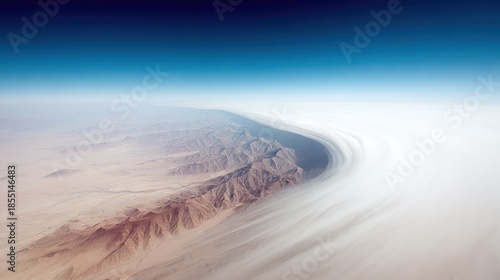 Aerial view captures arid mountain range meeting vast expanse of low-lying cloud cover