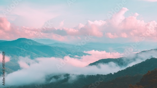 Layered mountain ridges emerge through low hanging atmospheric moisture under a pastel sky