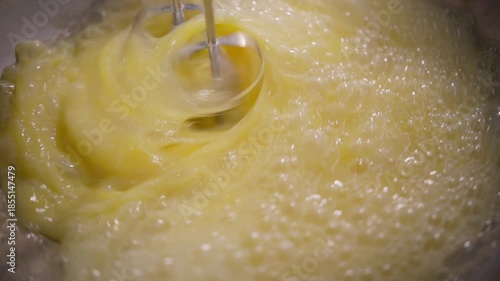 Mixer whips sweet egg mixture into bubbly foam creating richer texture for upcoming baked goods. Intensified swirling action supports cakes pastries mochi and various delicate confections