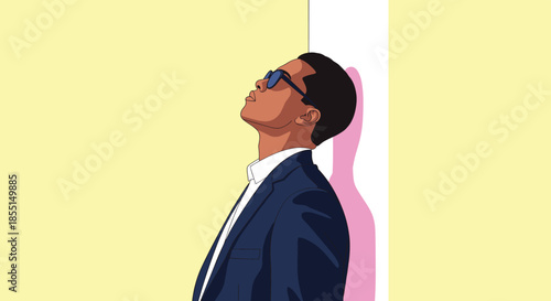 Stylish man in a blue suit and sunglasses leaning against a white pillar while looking upwards against a yellow background.