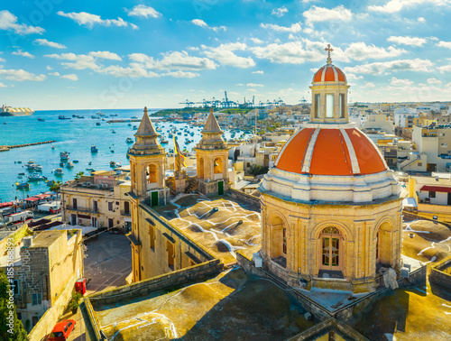 Drone view of famous Marsaxlokk fishing village, Sunday market. Church dome. Malta 