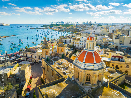 Drone view of famous Marsaxlokk fishing village, Sunday market. Church dome. Malta island