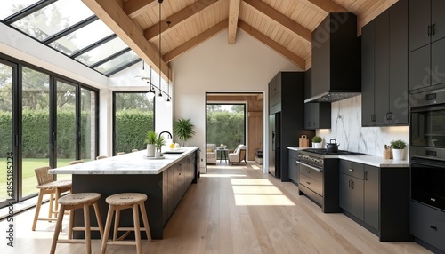 Modern open plan kitchen with large island, black cabinets, wood beams, skylight ceiling. Natural light streams in from large windows illuminating spacious, stylish, functional home interior design.