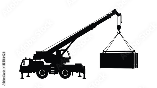 Silhouette of a mobile crane lifting a shipping container
