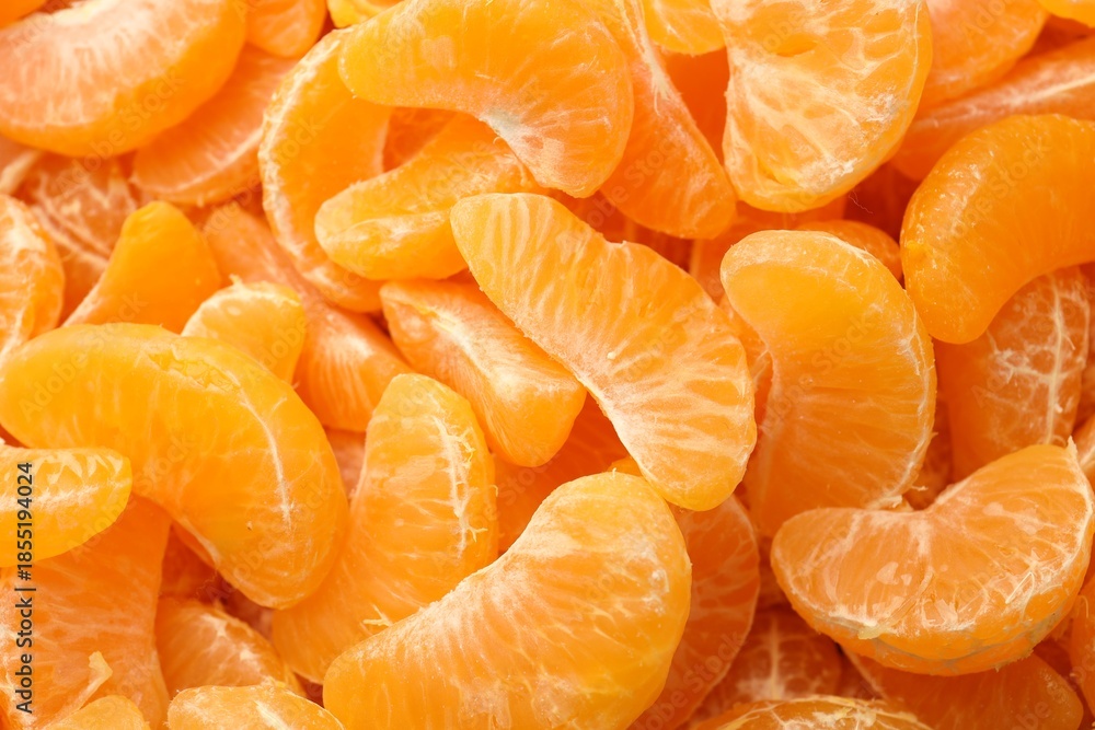 Fototapeta premium Many ripe peeled tangerines as background, top view
