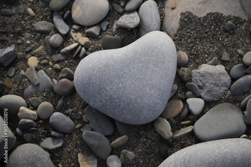 Natural heart-shaped stone on the seashore, symbolizing love, harmony, and emotional connection with nature.High quality photo