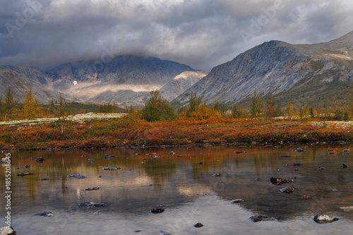 Autumn Mountain Valley Landscape With Dark Clouds Over Vibrant Tundra and Lake
