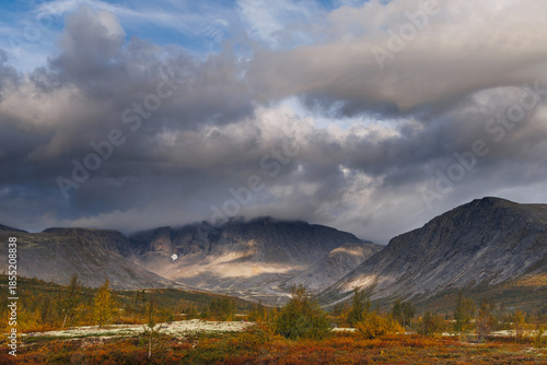 Autumn Mountain Valley Landscape With Dark Clouds Over Vibrant Tundra and Lake
