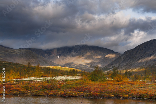 Autumn Mountain Valley Landscape With Dark Clouds Over Vibrant Tundra and Lake