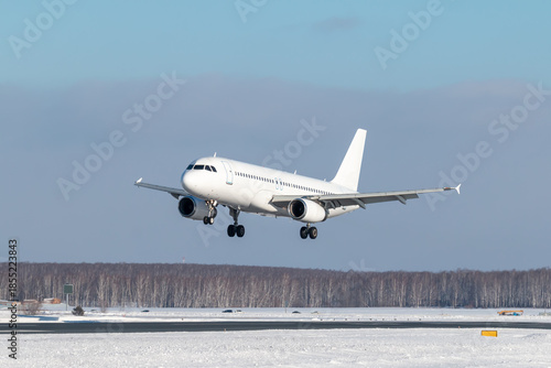 White passenger plane landing at winter airport