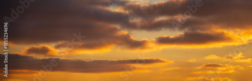 Warm sunset sky with soft glowing clouds and golden light. Peaceful evening atmosphere, natural background with copy space, perfect for nature and travel concepts.