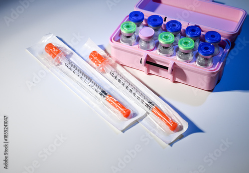 Photos Glass Vials in Pink Case with Peptide Compounds Next to Single Use Syringes