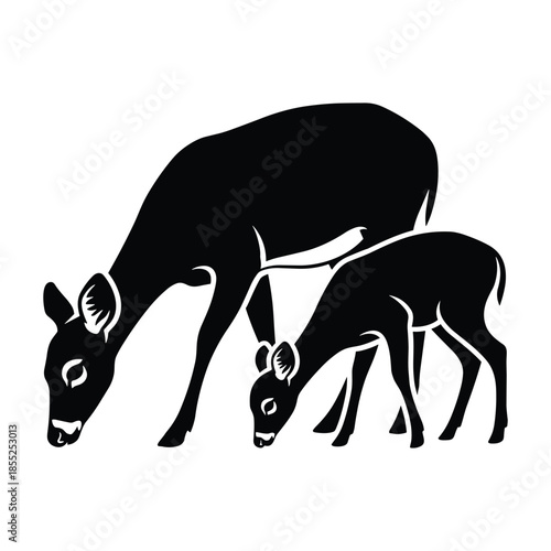 Mother deer and fawn grazing in silhouette