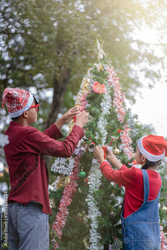 The children are celebrating Christmas and decorating the Christmas tree together.