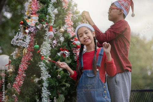 The children are celebrating Christmas and decorating the Christmas tree together.