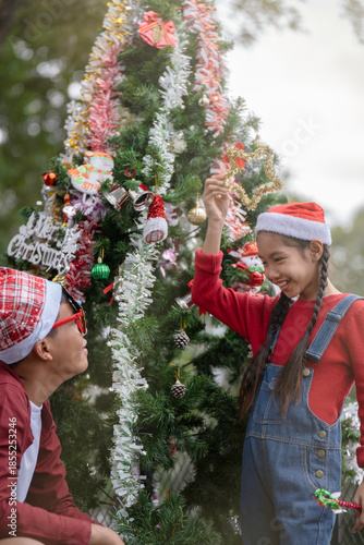 The children are celebrating Christmas and decorating the Christmas tree together.