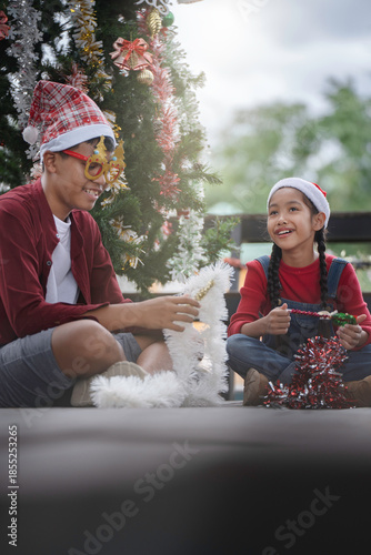 The children are celebrating Christmas and decorating the Christmas tree together.