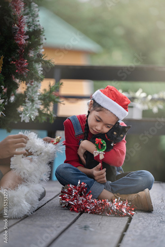 The children are celebrating Christmas and decorating the Christmas tree together.