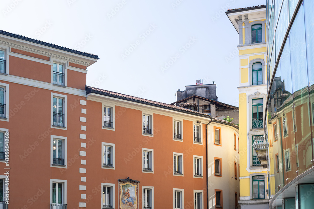 Obraz premium Colorful European Street With Orange Building Facade And Modern Glass Reflection