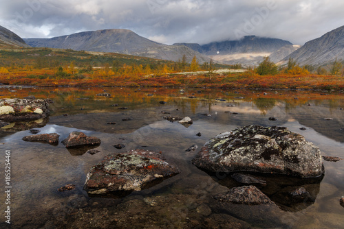 Autumn Mountain Lake Landscape With Reflections, Large Rocks, and Calm Water in Remote Valley
